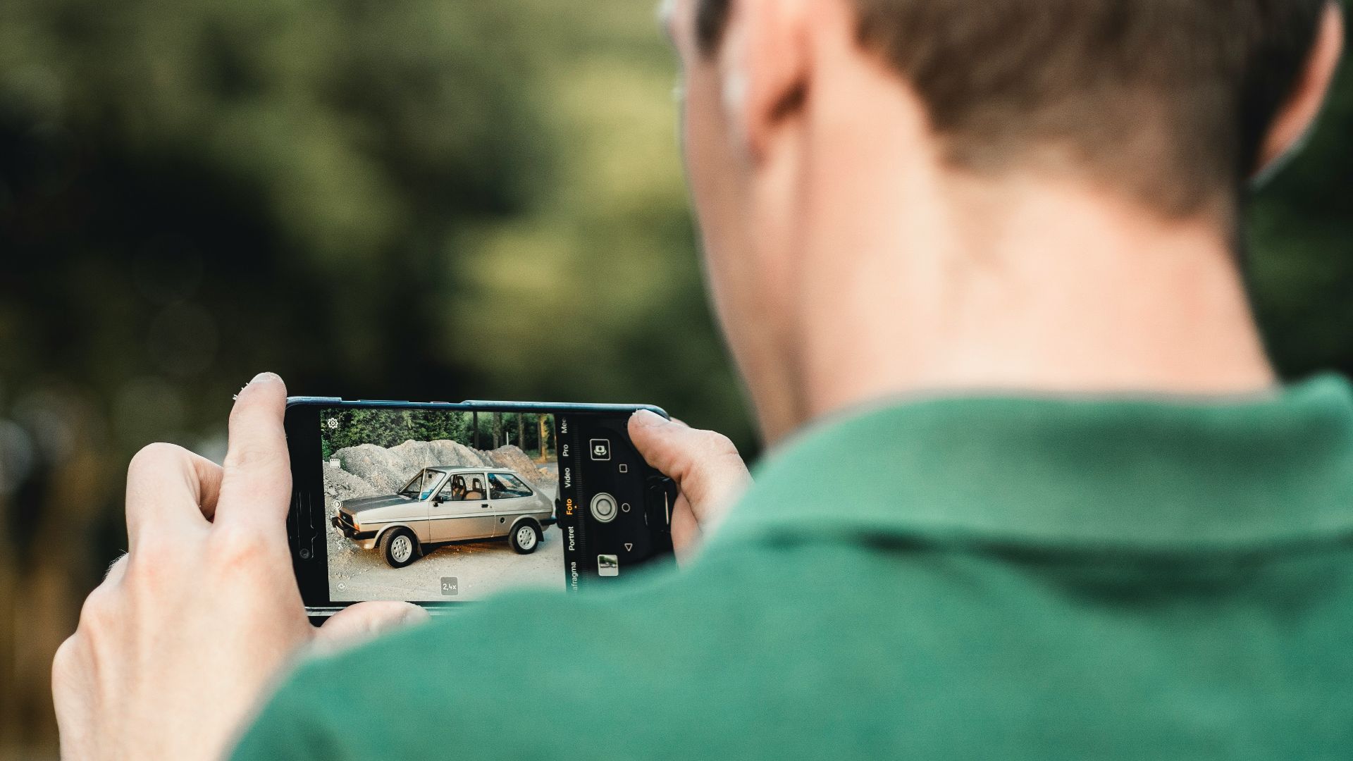 man taking photo of car