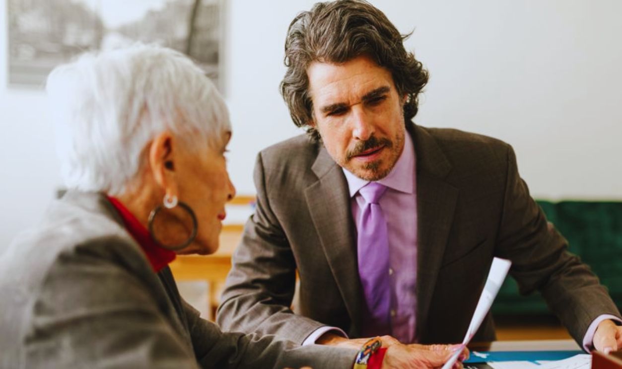 Elderly business professionals discussing reports in a modern office setting