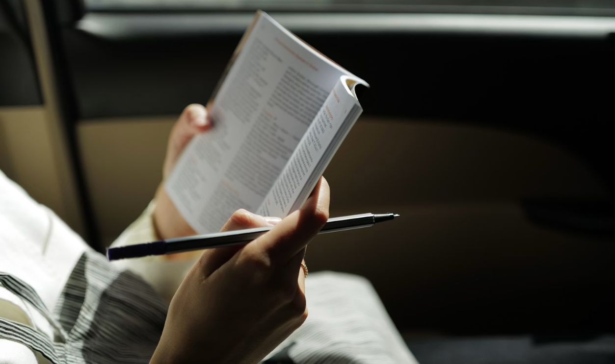 person in gray and black long sleeve shirt reading book