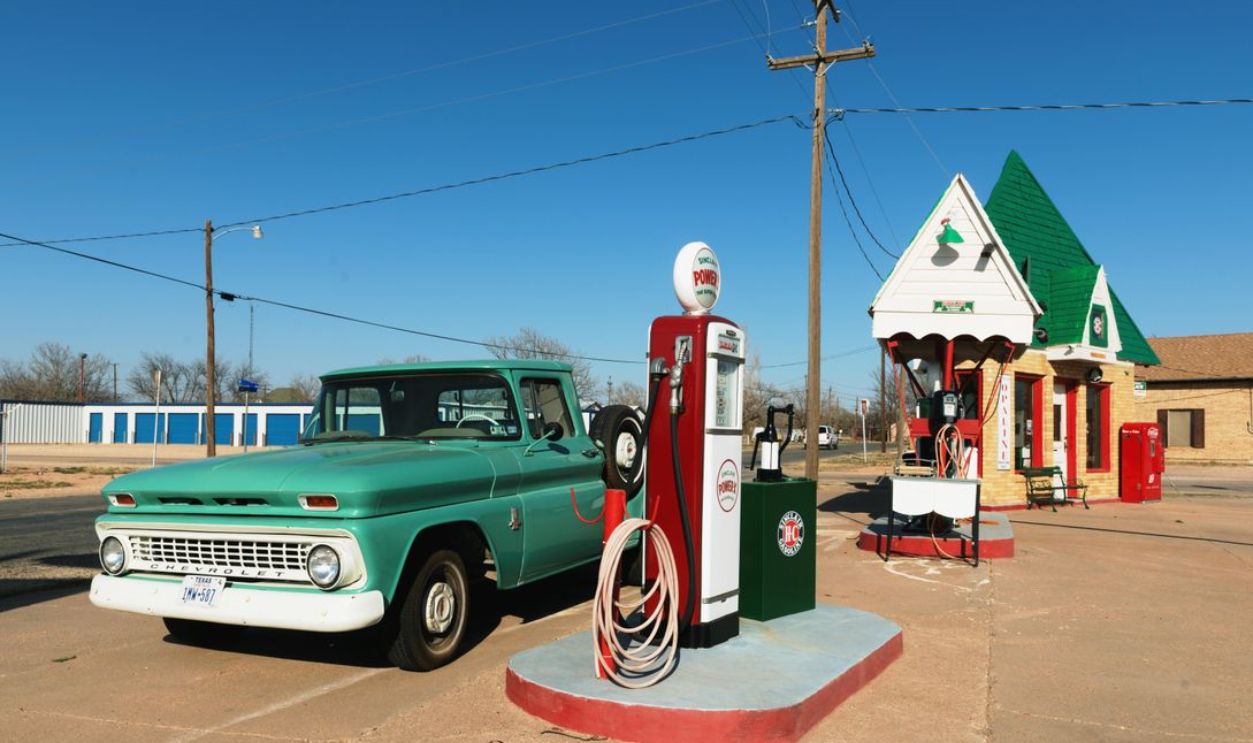 A retro gas station with a vintage truck and bright blue skies, ideal for travel nostalgia.