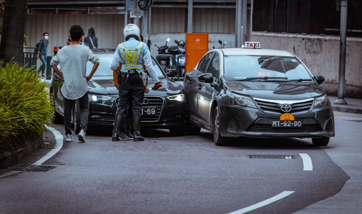 Two drivers and a police officer at a roadside accident