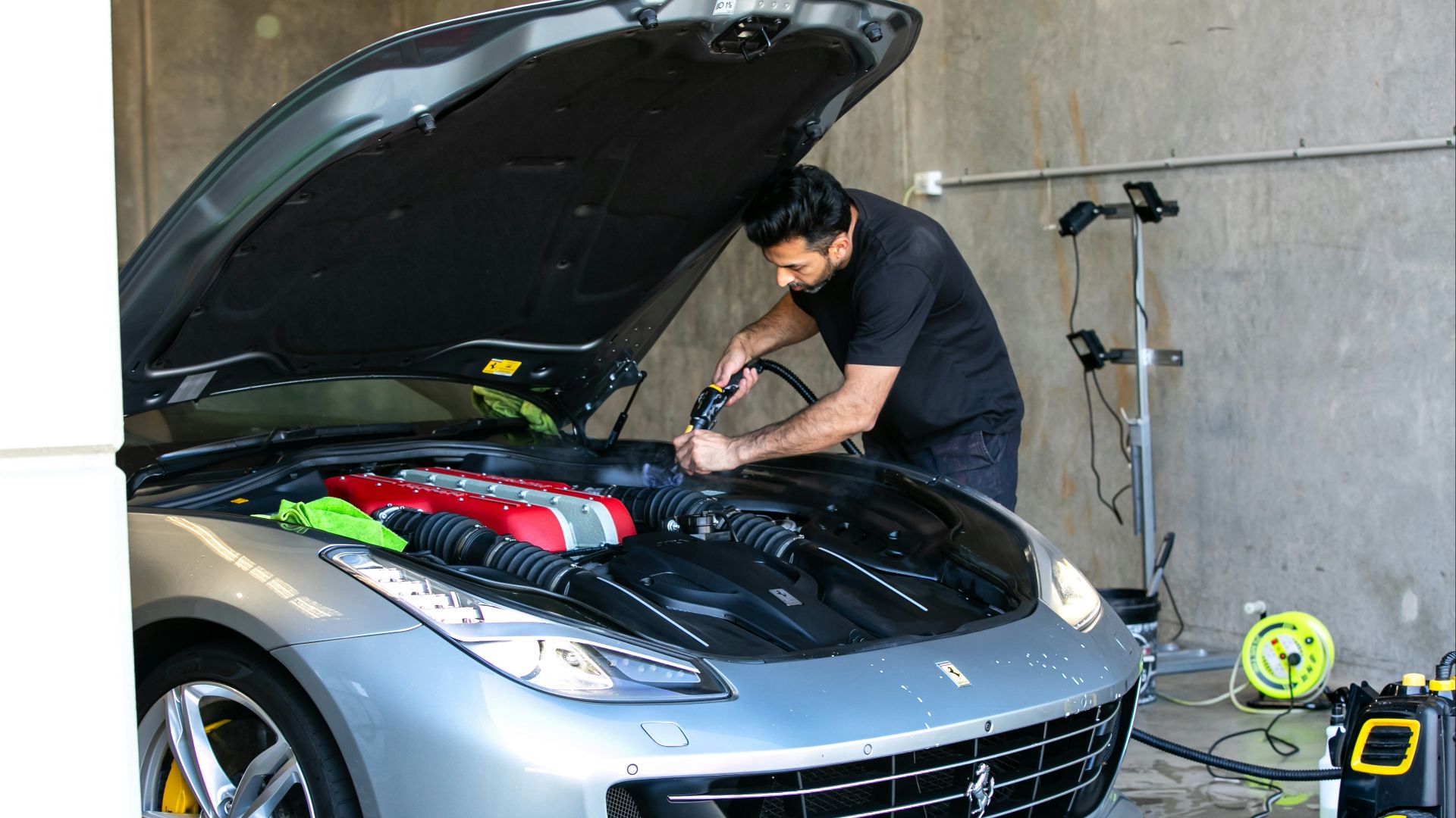 A mechanic is working on a ferrari car.