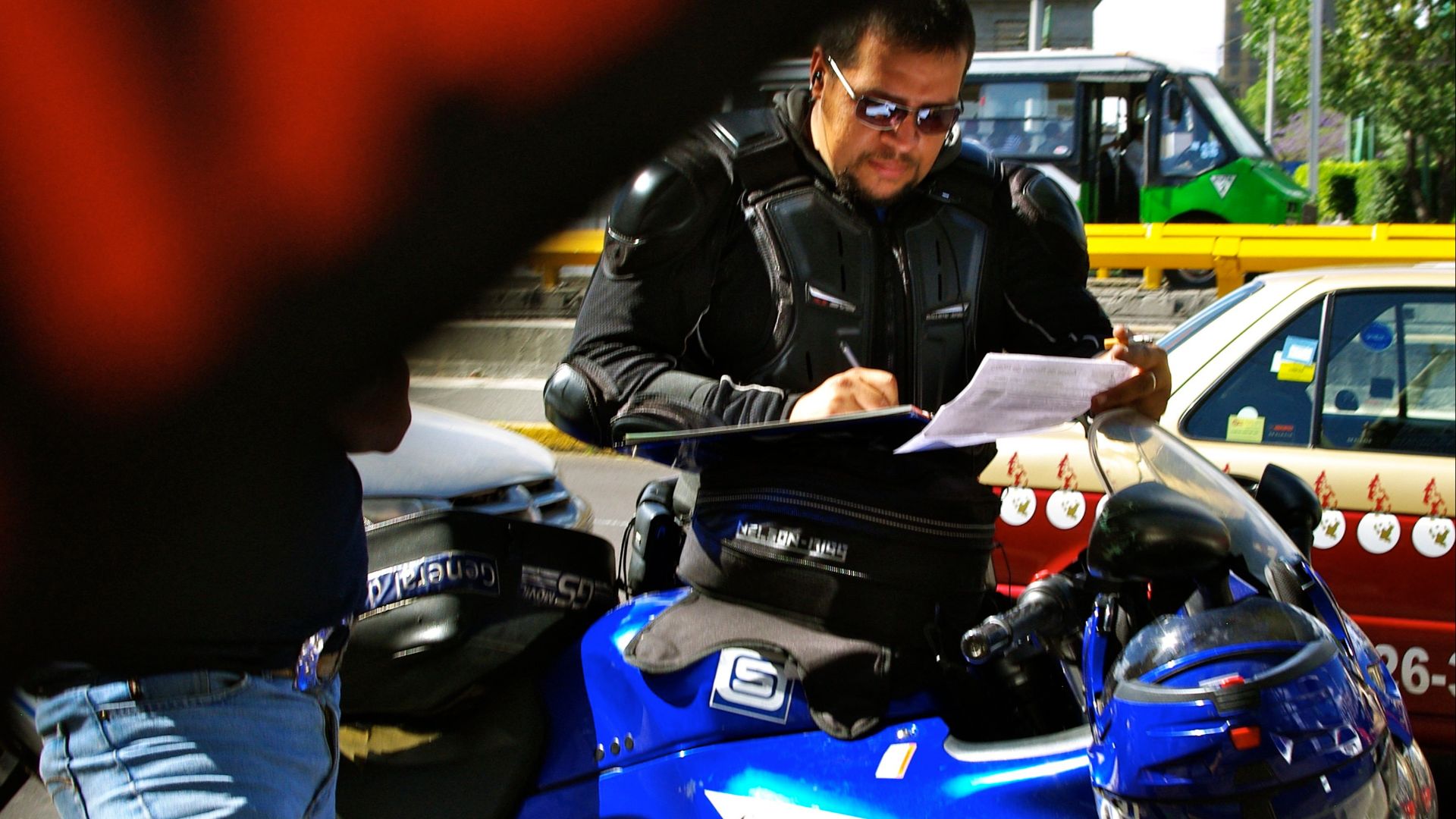Mexico City motorcycle police officer writing a traffic or parking ticket, March 2010.
Other information

Photo by George Garrigues.