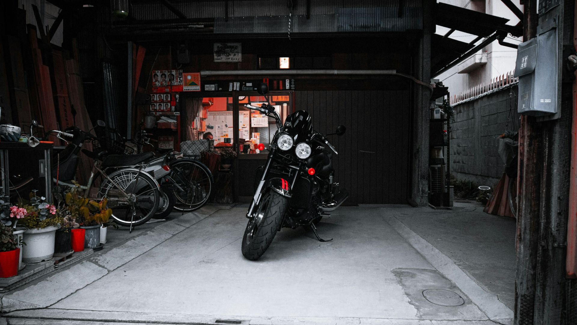 a motorcycle parked inside of a garage next to bicycles