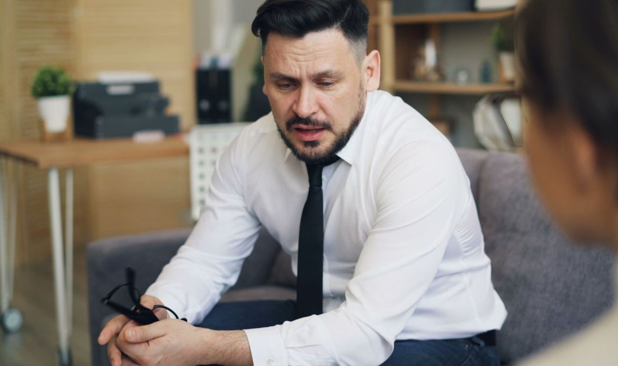Psychotherapist in conversation with client, addressing emotional concerns in a calm office setting