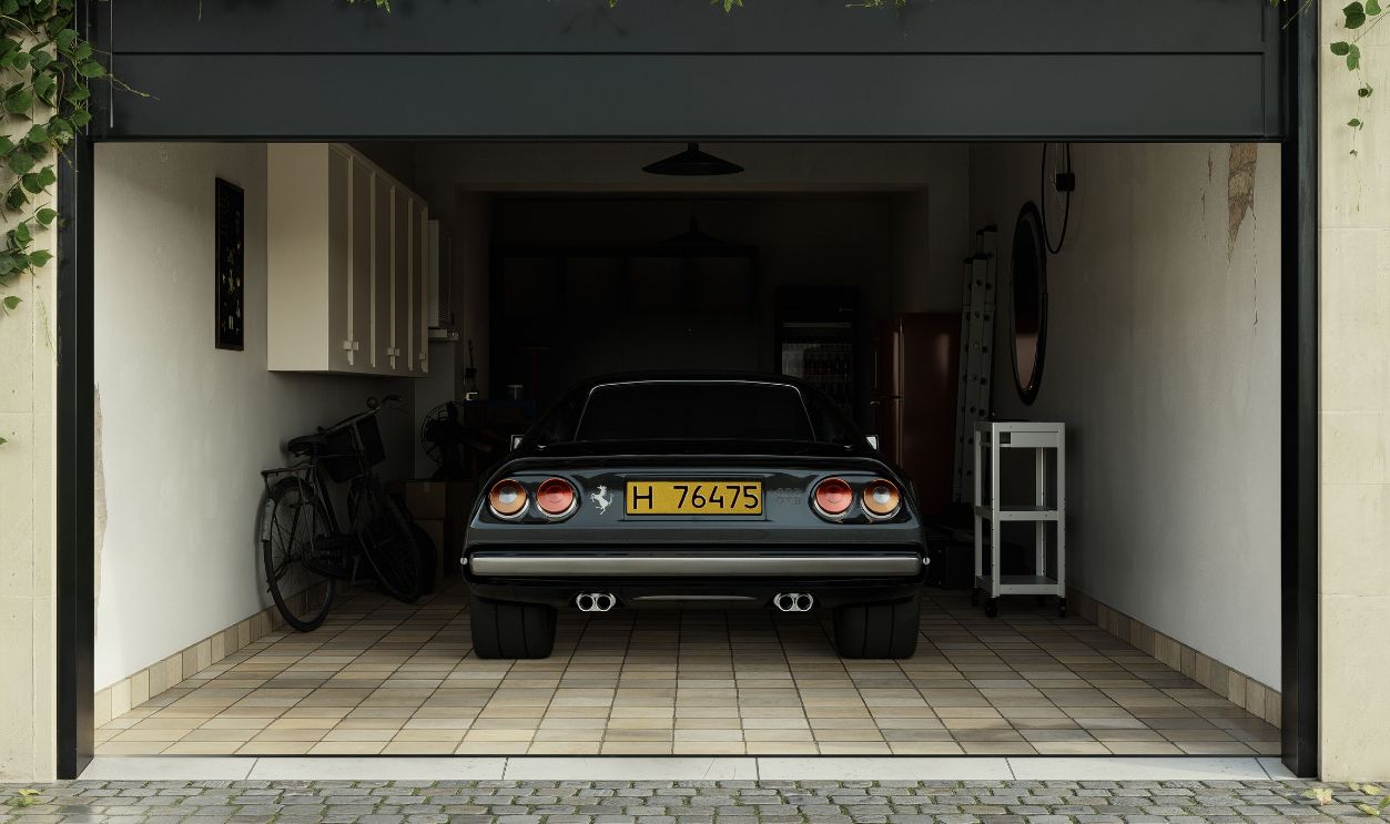 A classic car parked in an ivy-covered garage with a cobblestone driveway