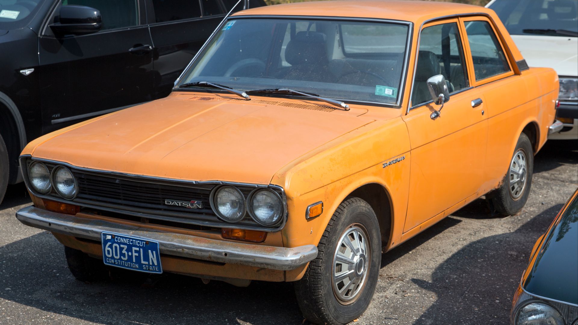 1970-1972 Datsun 510 2-door sedan in Mexican Orange (918) at an import car specialist/cemetery in Water Mill NY.
