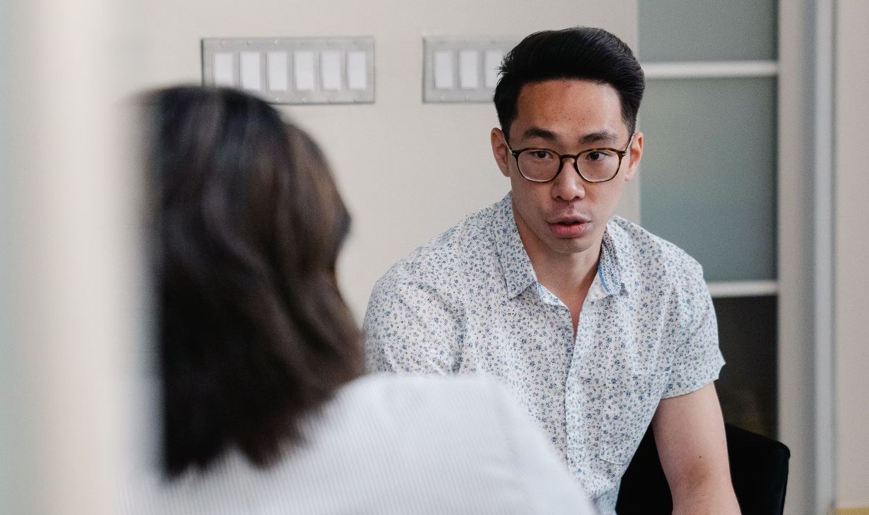 Two colleagues discuss work matters in a modern office setting