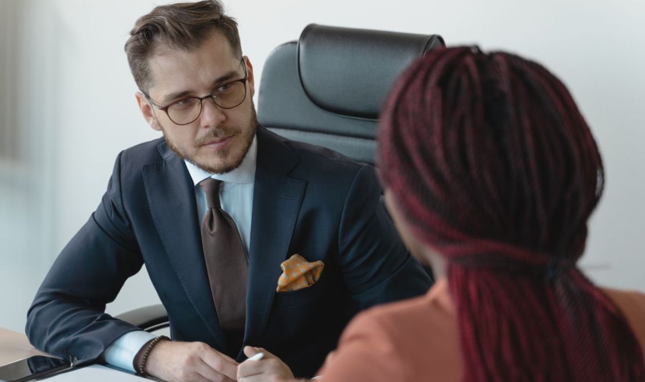 Two professionals engage in a serious discussion at a corporate meeting.