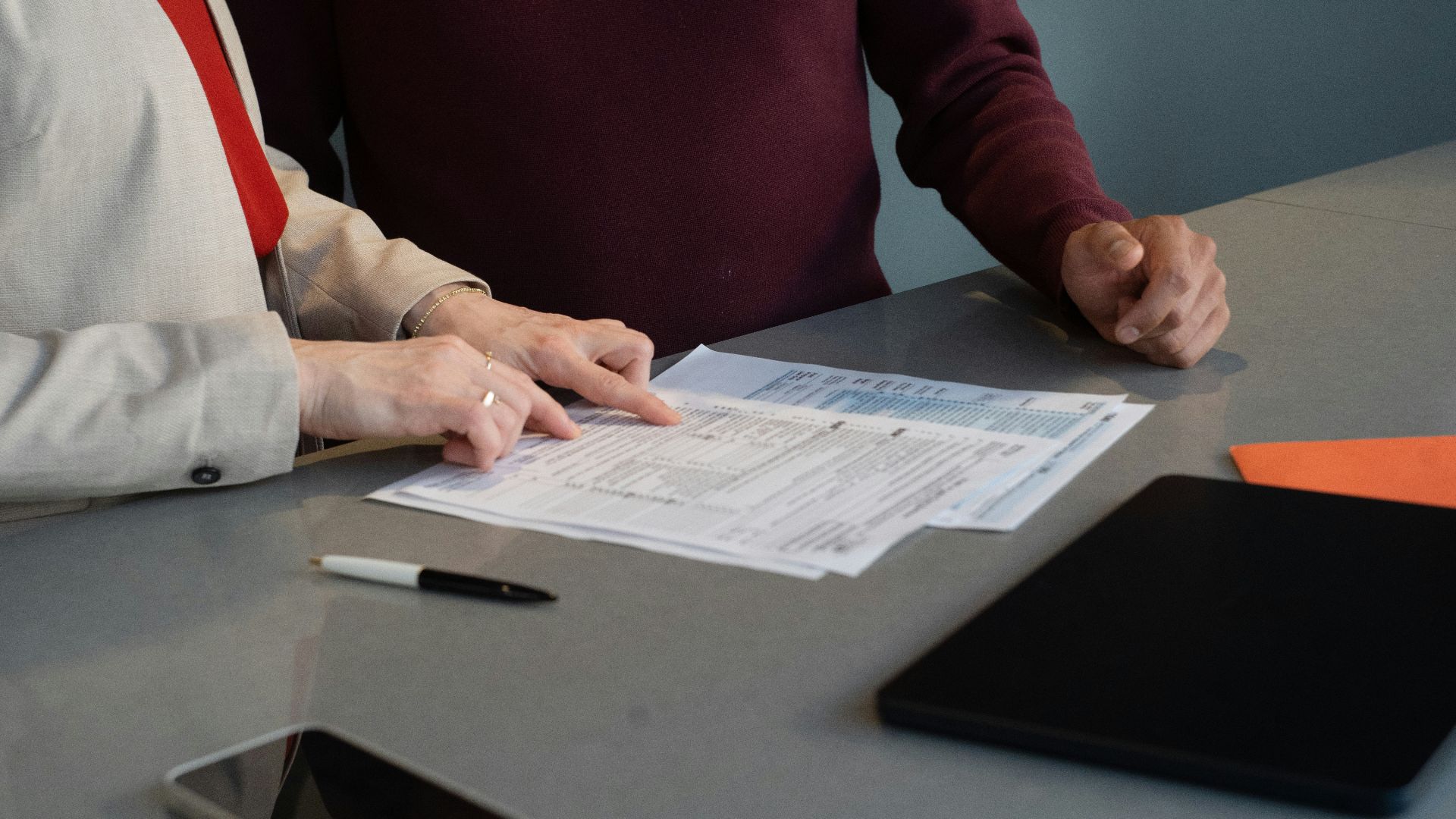 Two people reviewing documents at a table.