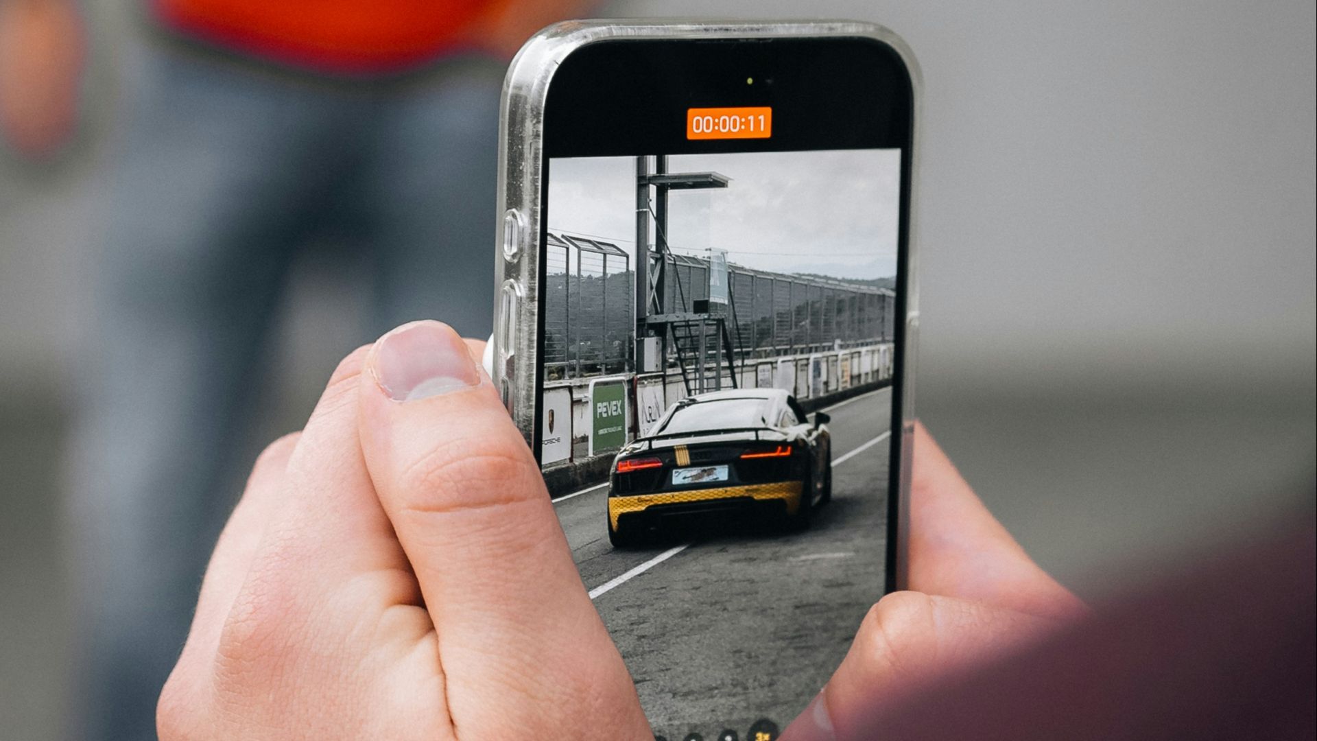 a person taking a picture of a car on a cell phone