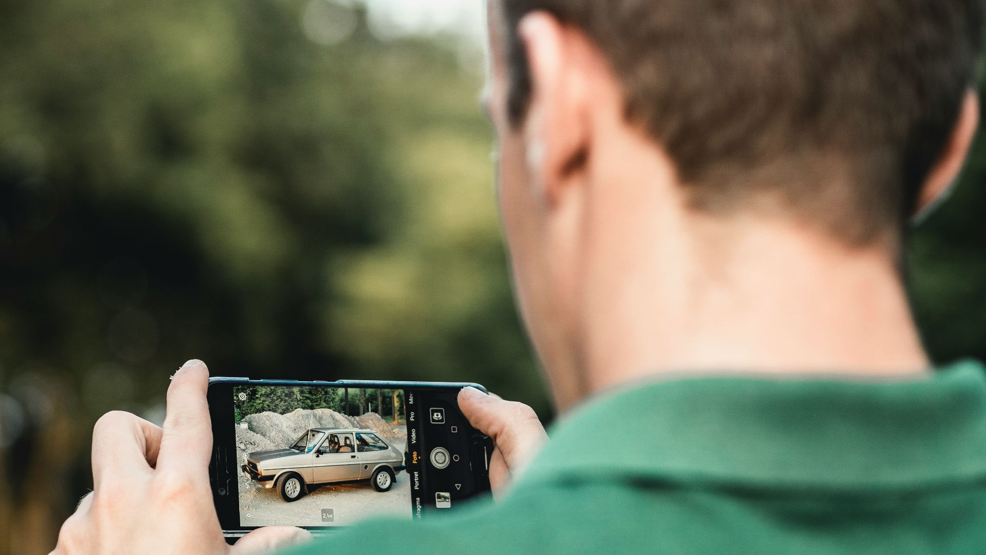 man taking photo of car