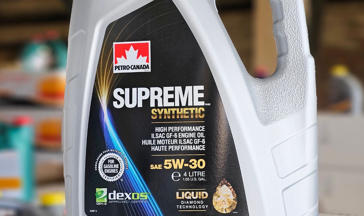 Saint-Petersburg, Russia - June 04, 2024: 4 liter plastic canister with Supreme synthetic 5W30 engine oil in an industrial warehouse. Blurred background. Vertical view.