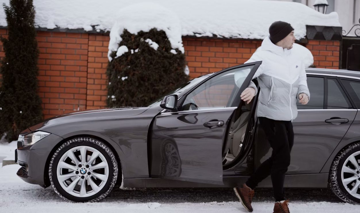 a woman is getting out of a car in the snow