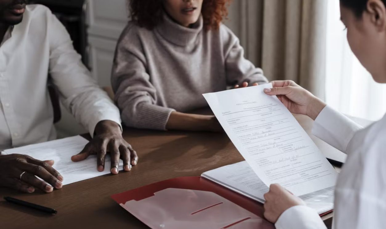 A diverse group of individuals discussing documents in a professional office environment.