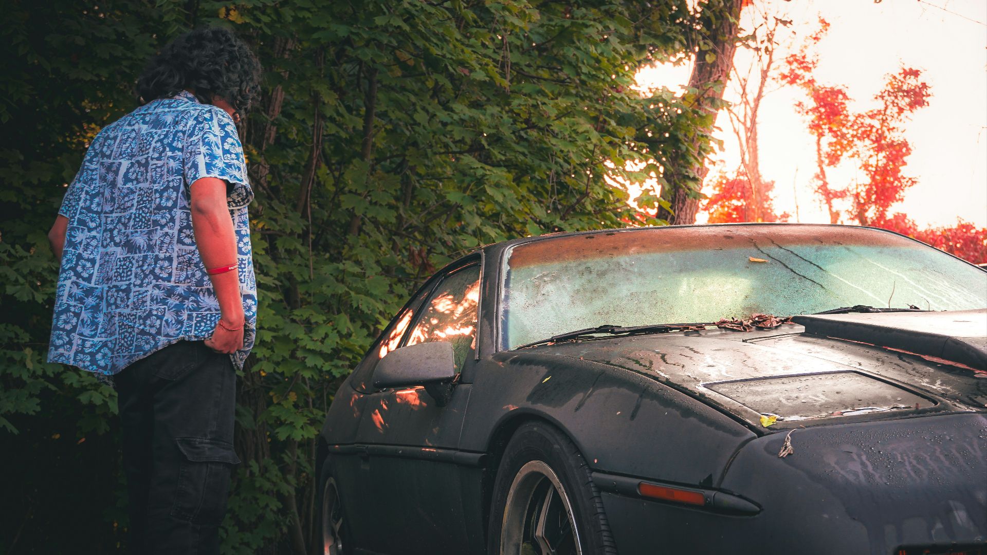 A person standing next to a parked car
