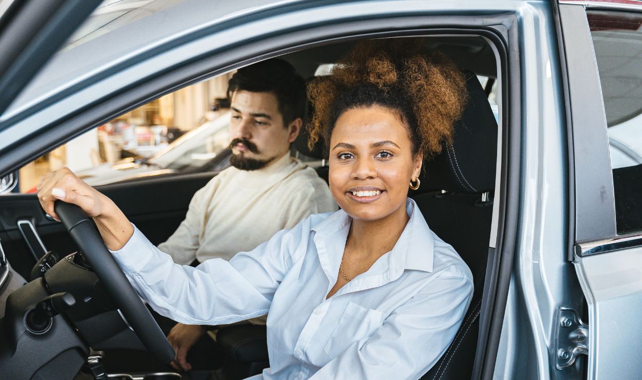 Woman sitting in the driver's seat of a modern car with a male passenger