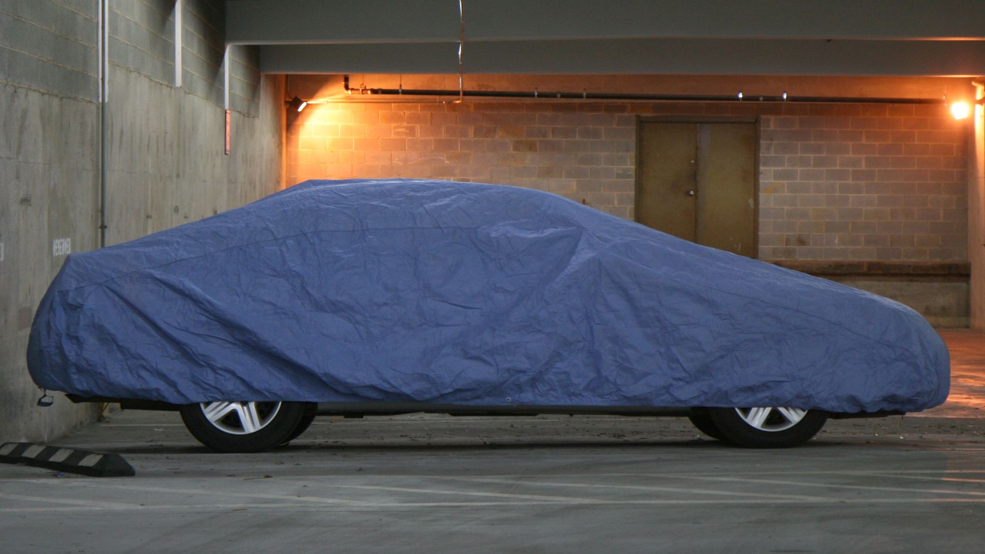 A car parked and covered inside a parking garage in Durham, North Carolina.