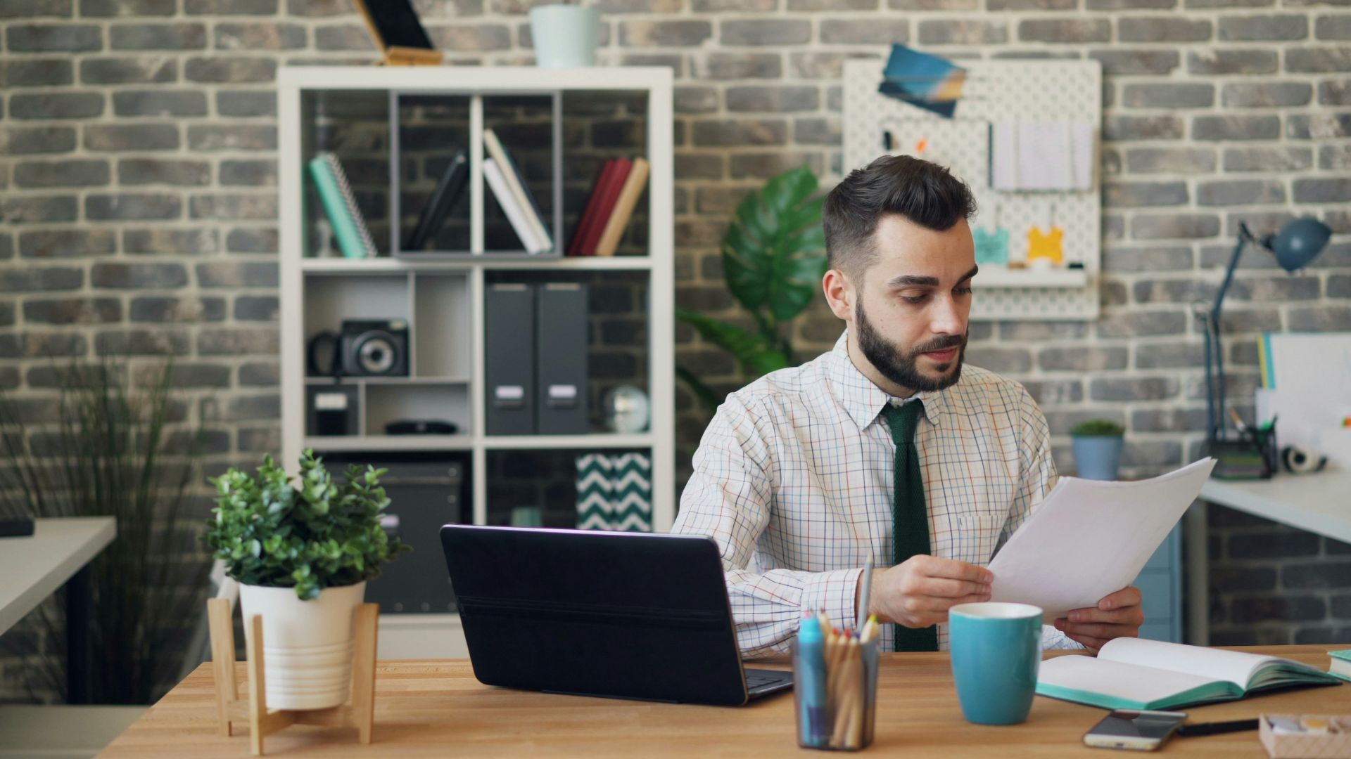 a man sitting at a desk in front of a laptop