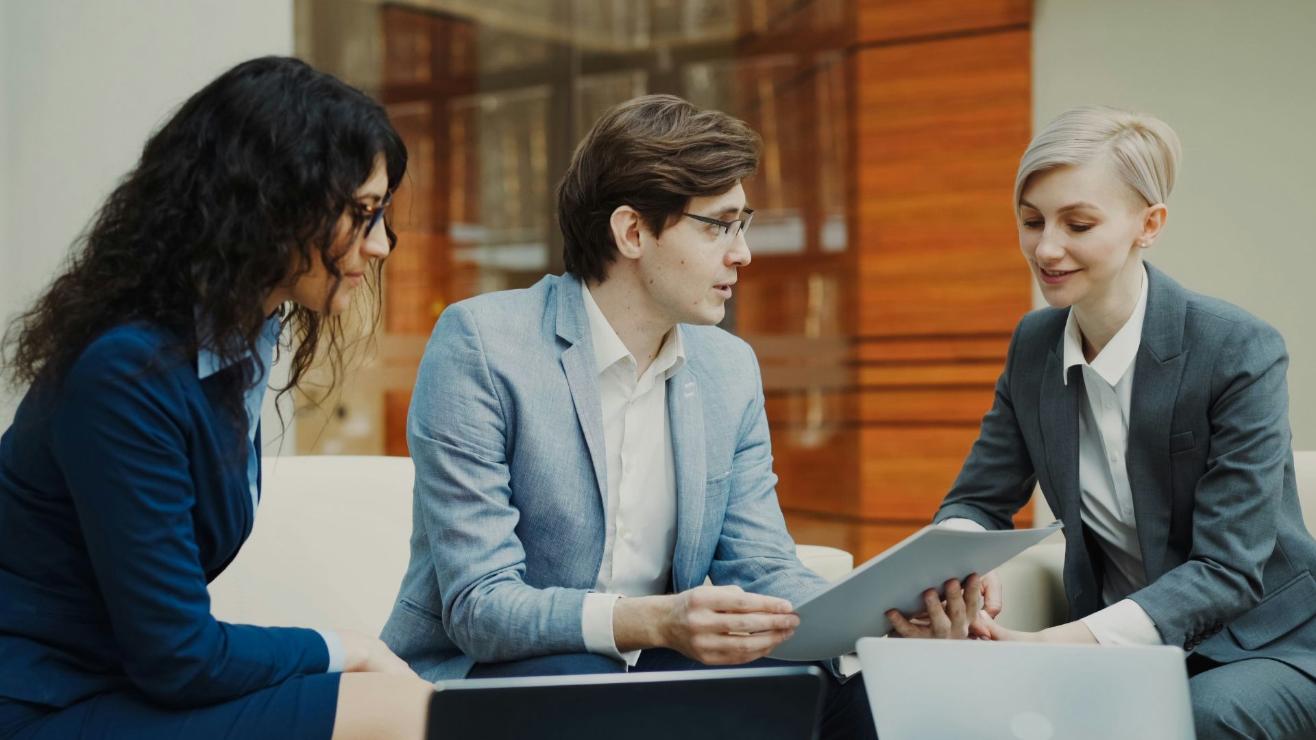 Three professionals discussing documents at a table.