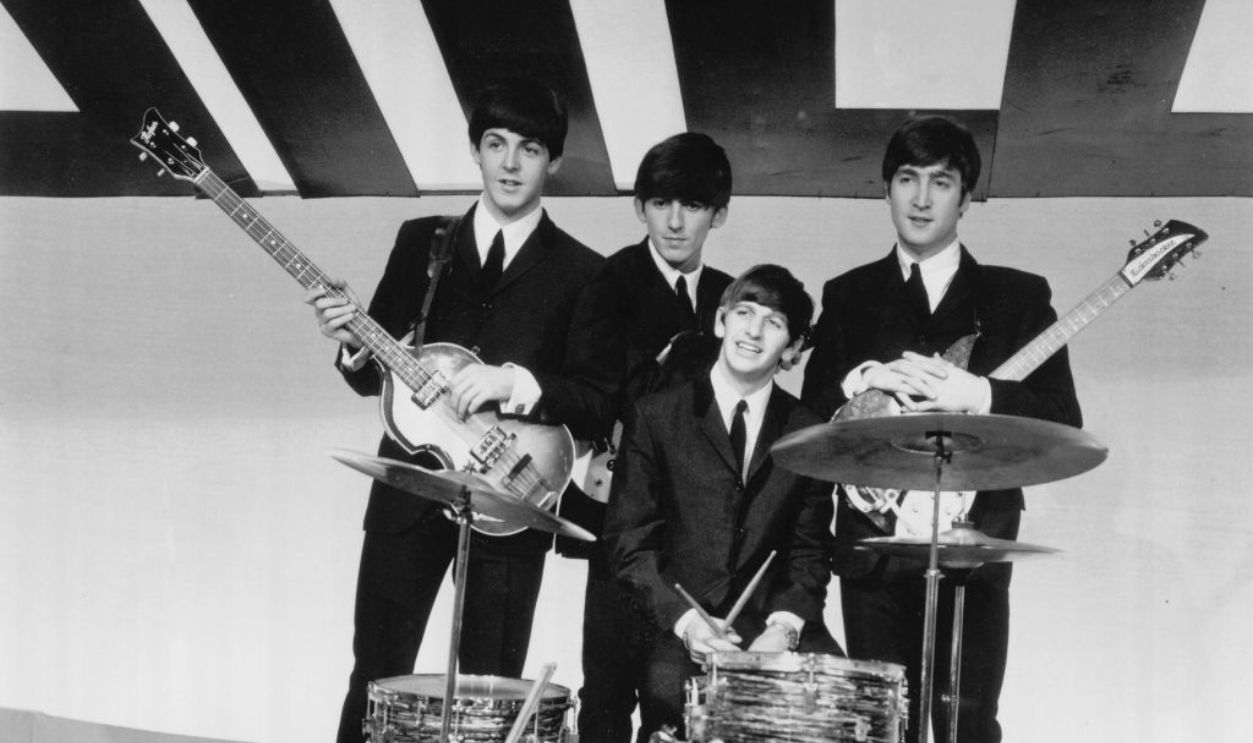 English rock and pop group The Beatles, from left Paul McCartney, George Harrison, Ringo Starr and John Lennon (holding his 1958 Rickenbacker 325 guitar) posed together on stage during rehearsals for the ABC Television music television show 'Thank Your Lu