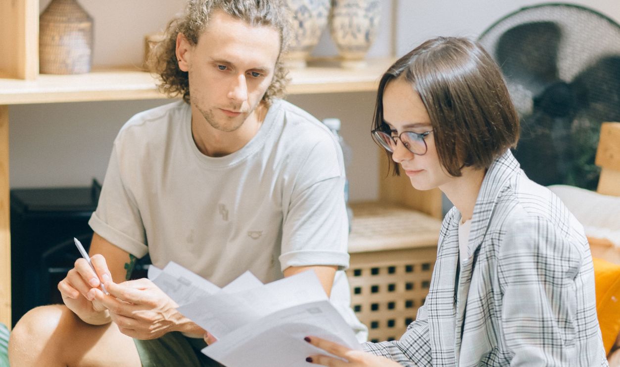 A man and woman discussing documents in a cozy workspace 