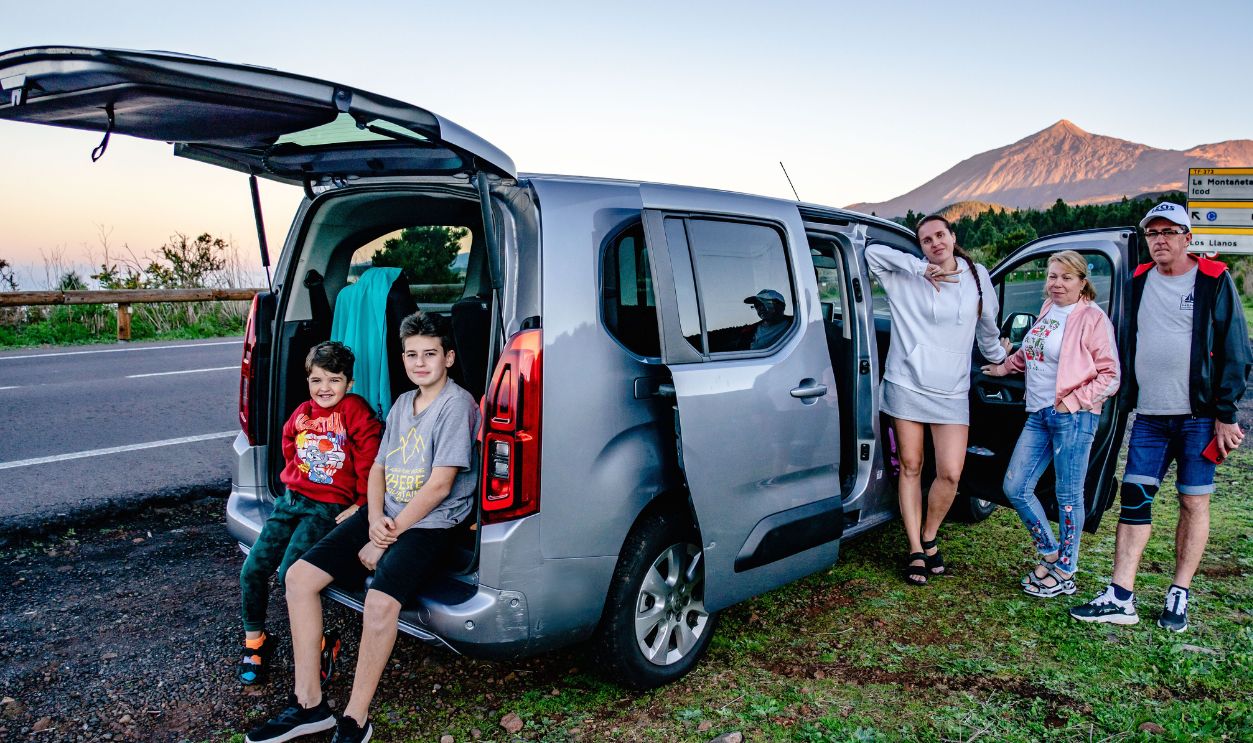 A family enjoys a scenic road trip by Mount Teide, Spain, with a van 