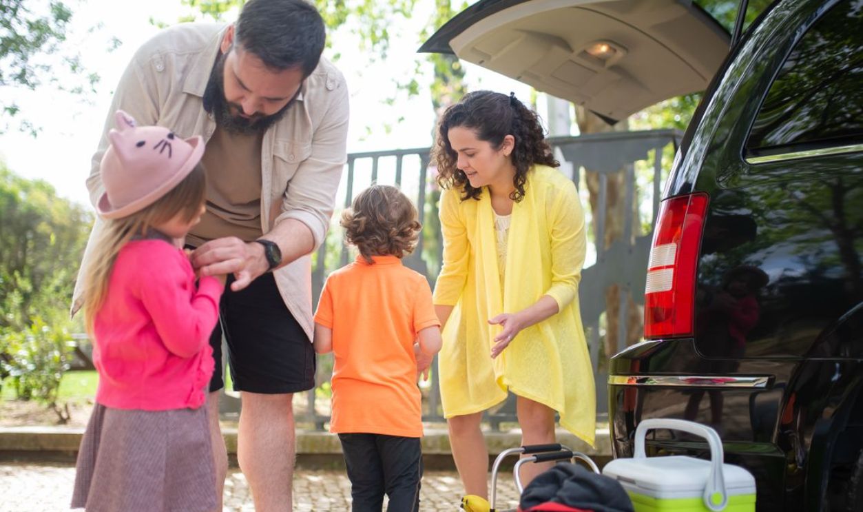 Cheerful family preparing car for a day trip in sunny Portugal.