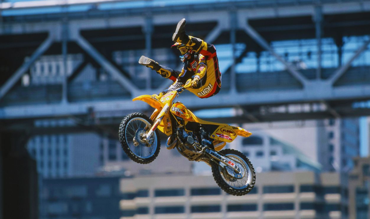 Gettyimages - 144557611, Travis Pastrana, SAN FRANCISCO, CA - JUNE 25: Travis Pastrana competes in the 1999 X Games on June 25, 1999 on Piers 30 & 32 in San Francisco, California. Pastrana won the Motocross Freestyle event with a record total of 99.0 points. The San Francisco Bay Bridge is visible in the background.