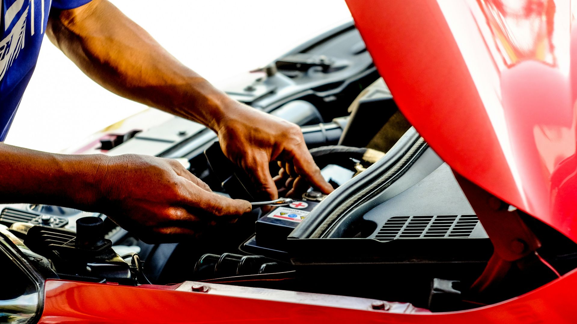 person fixing car during daytime