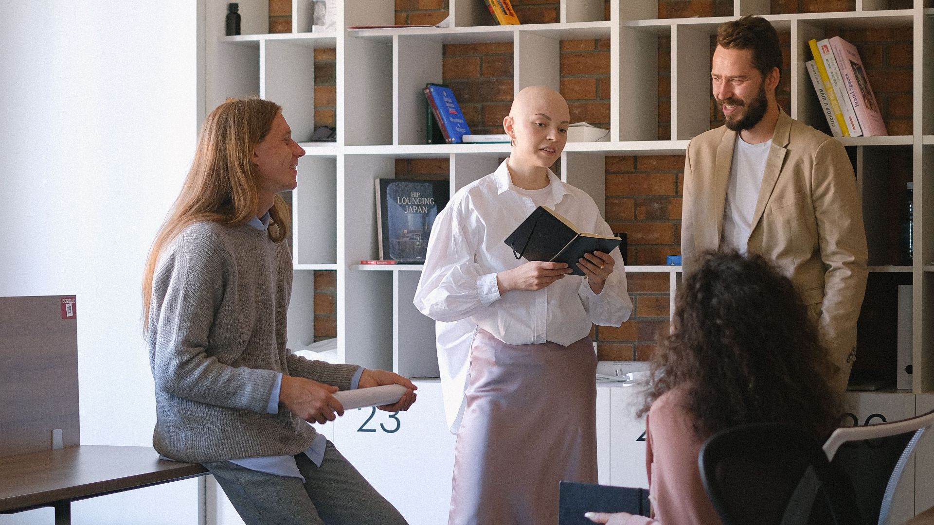 Coworkers dressed in formal clothes having business conversation while working on project together in modern office