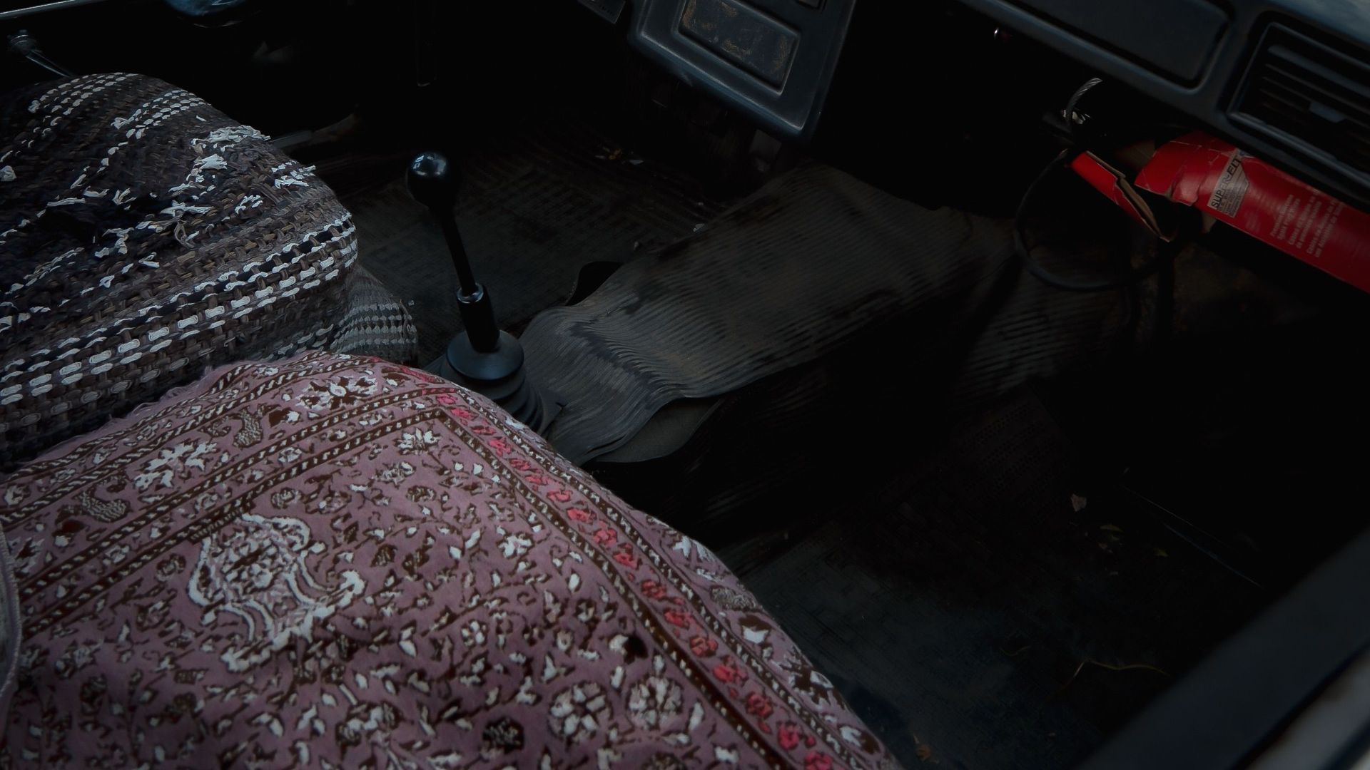 Interior view of a vintage car showcasing retro design elements and patterned seat covers.