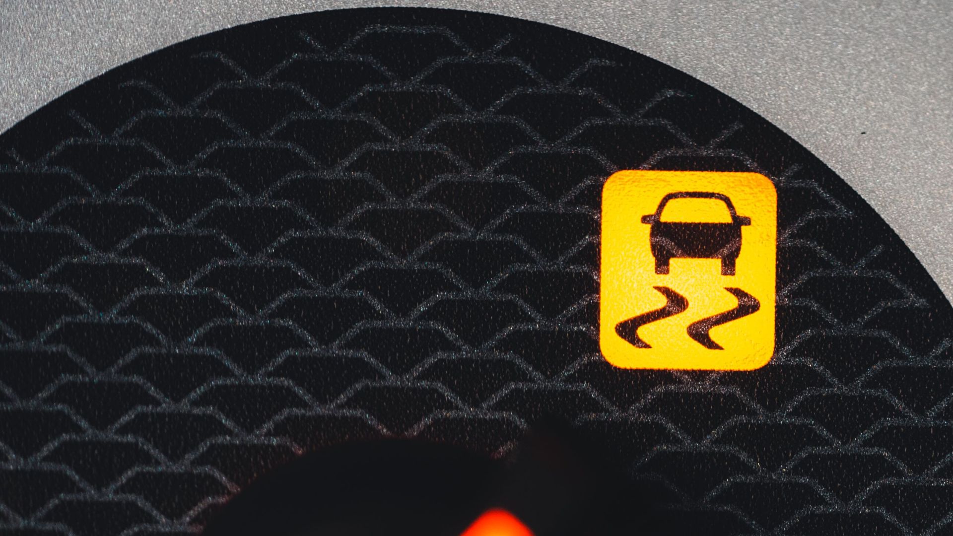 Close-up of a car dashboard showing a yellow traction control warning light.