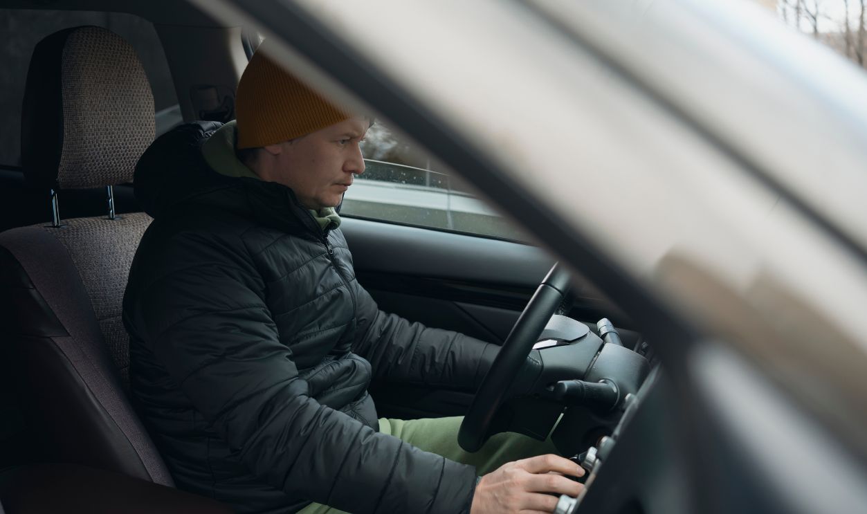 Mid adult male driver starts car in winter day