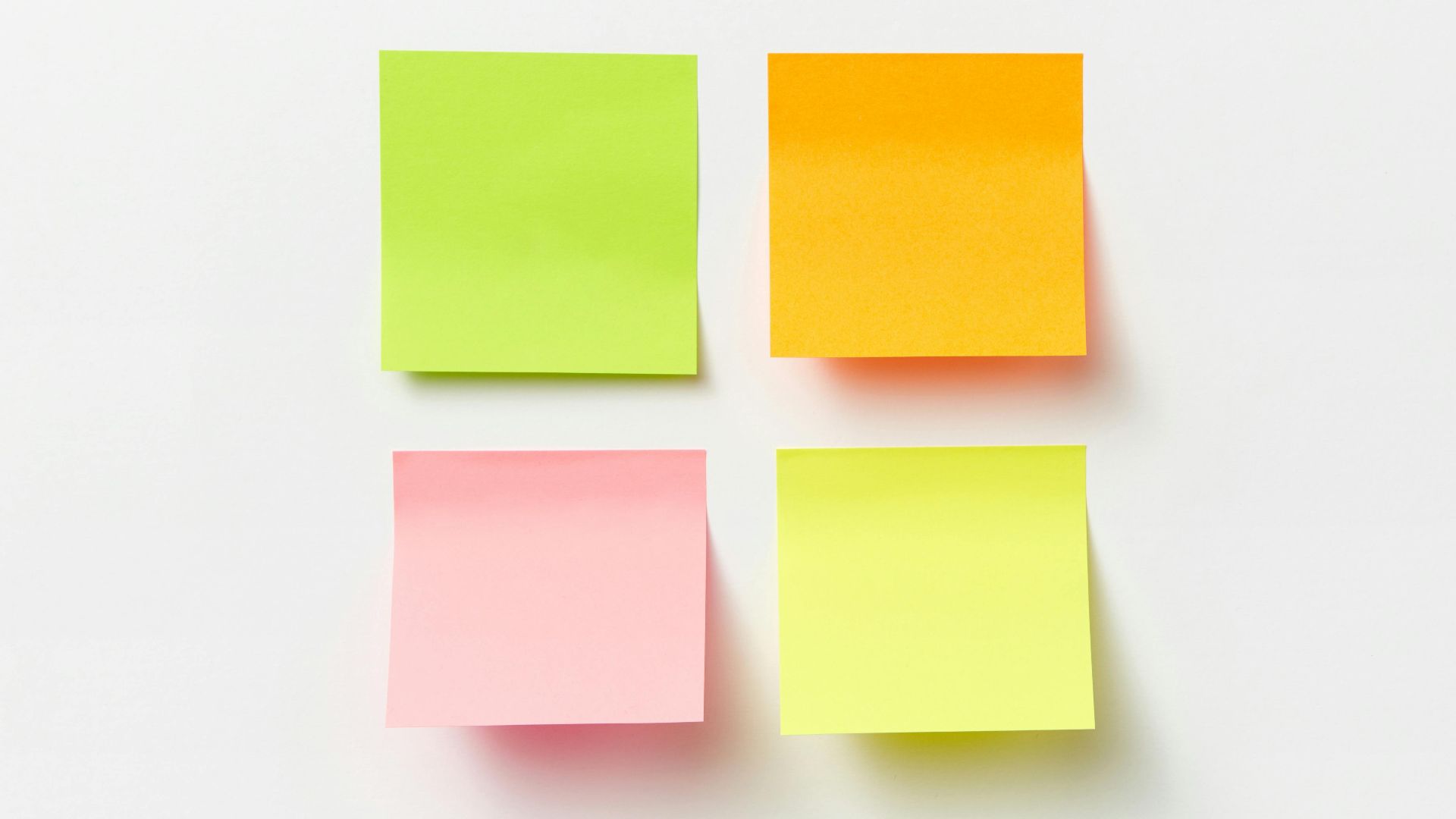 Four colorful sticky notes arranged on a clean white background.