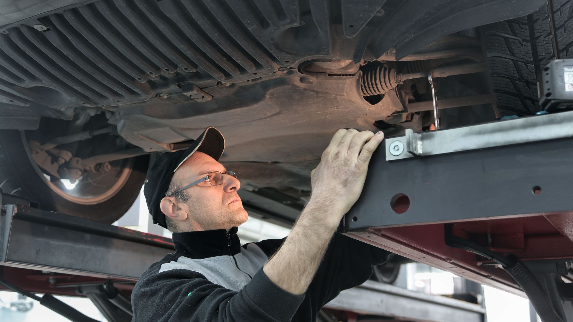 Professional mechanic conducting vehicle inspection in an auto workshop.