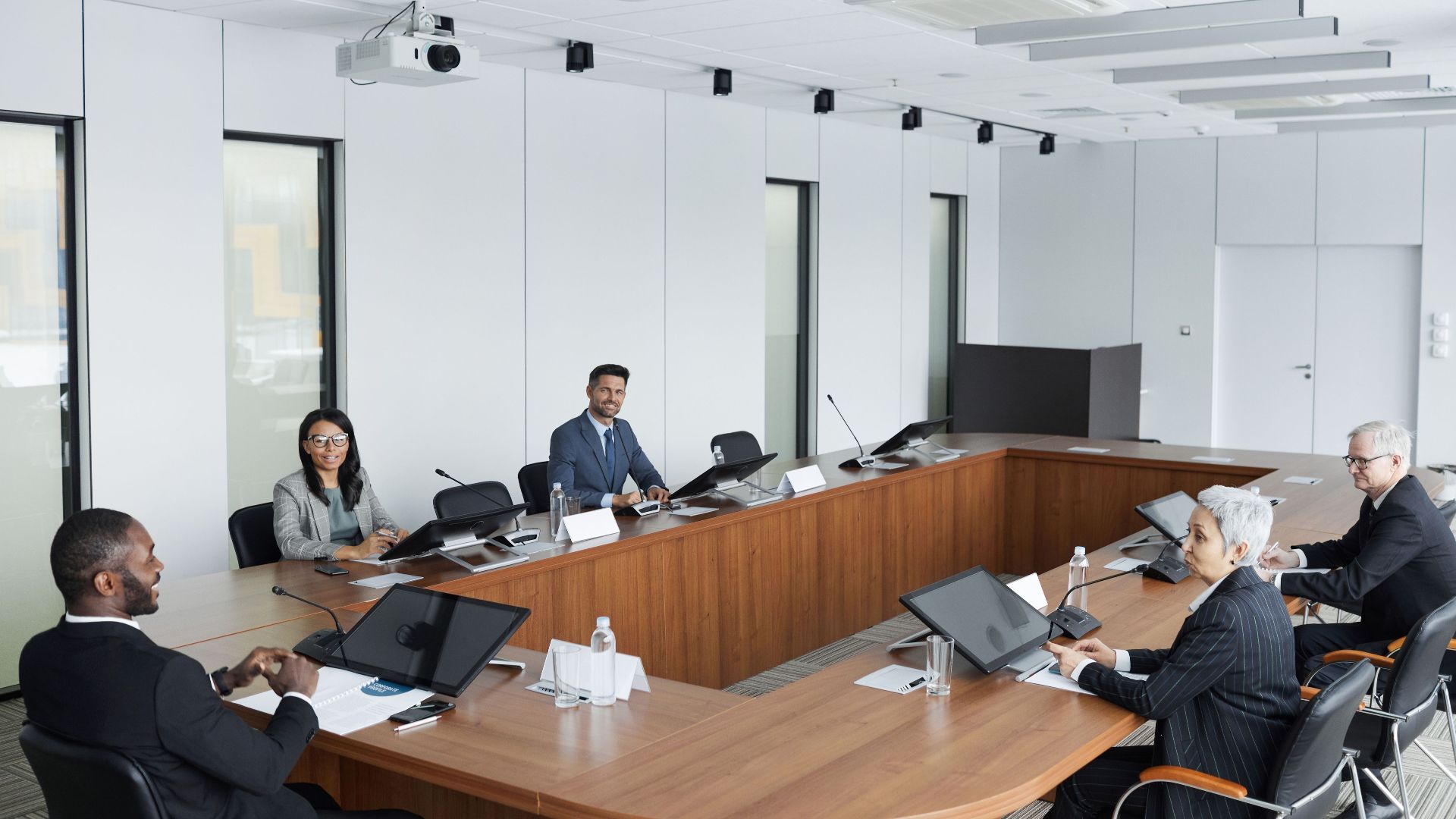 A multicultural group of professionals engaged in a business meeting in a modern conference room.