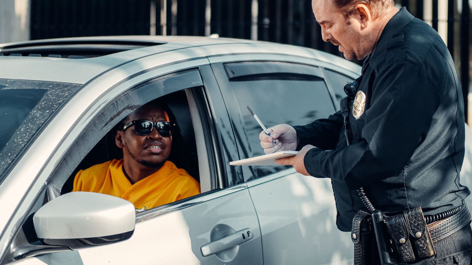 Police officer writes a traffic ticket for a driver during a routine stop.