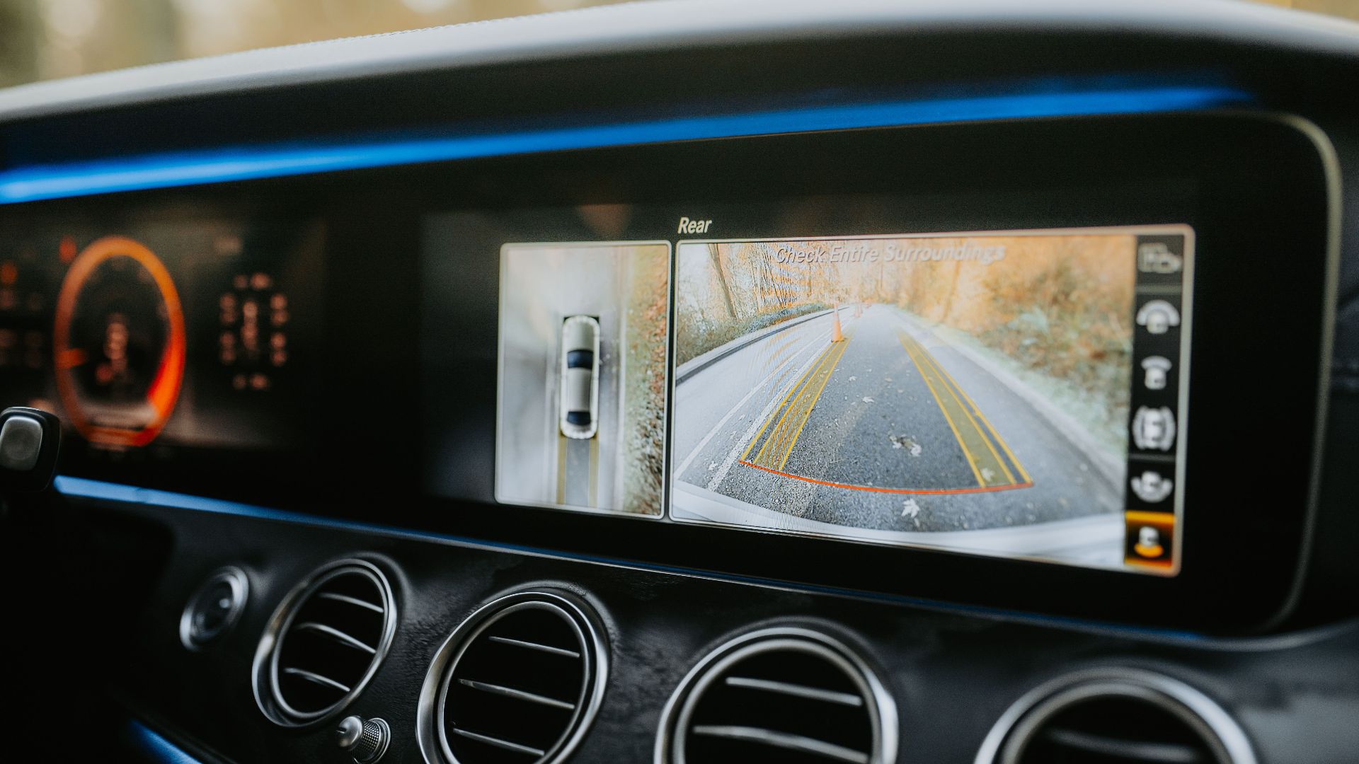 Close-up of a car dashboard showcasing a rear-view camera display and modern electronics.