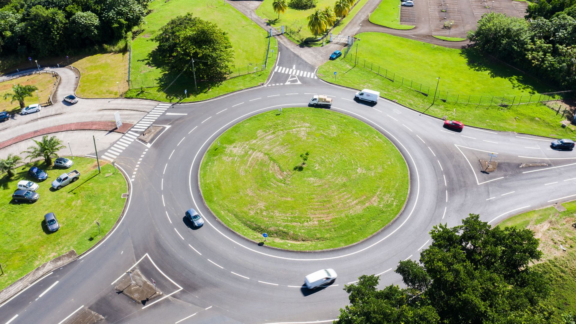 Aerial view of a roundabout surrounded by greenery and buildings in Martinique. Bright day scene.