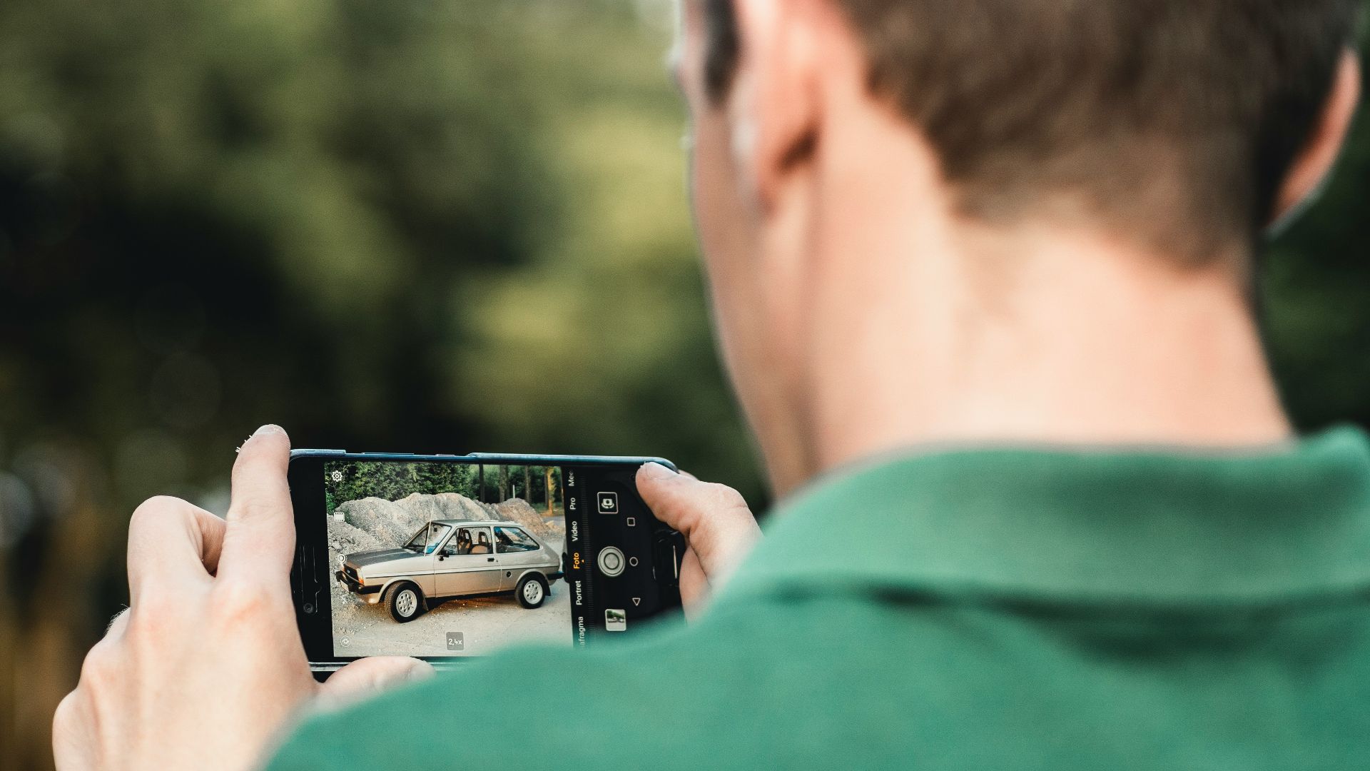 man taking photo of car