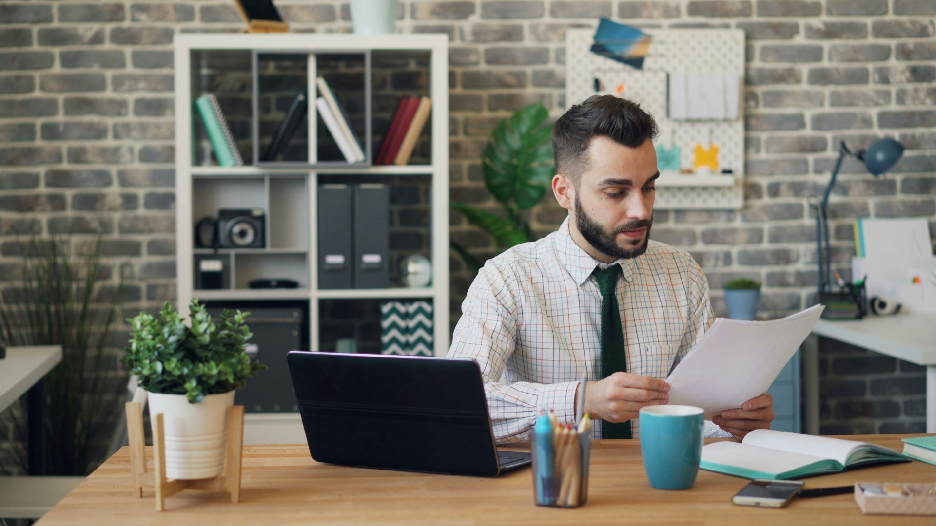 a man sitting at a desk in front of a laptop