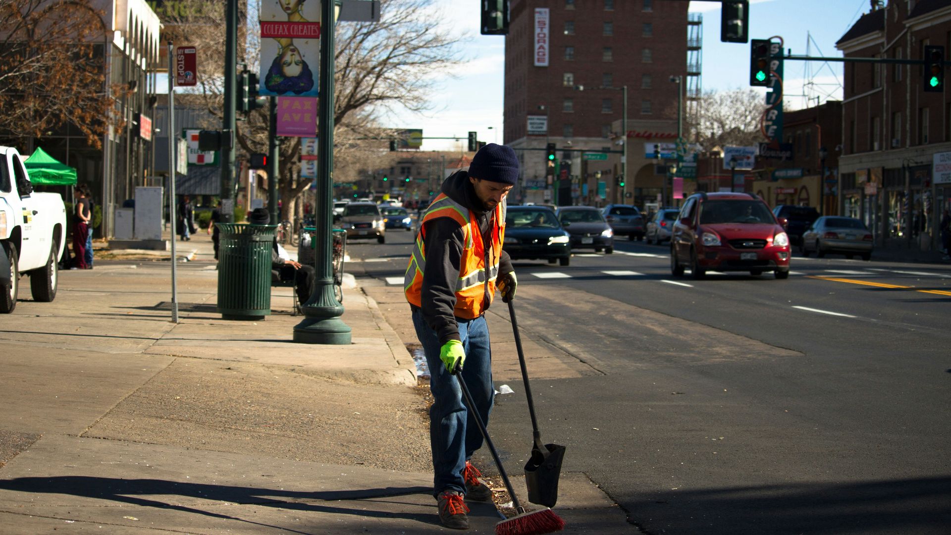 man cleaning the road near traffic light