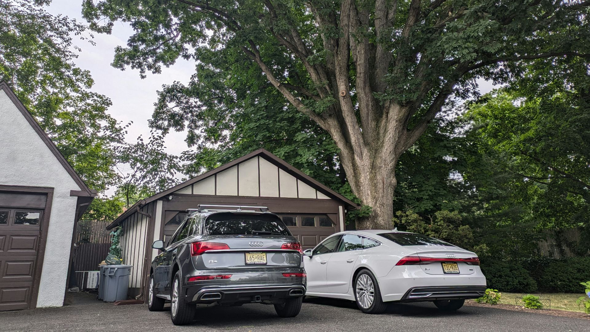 Two cars parked in front of a garage.