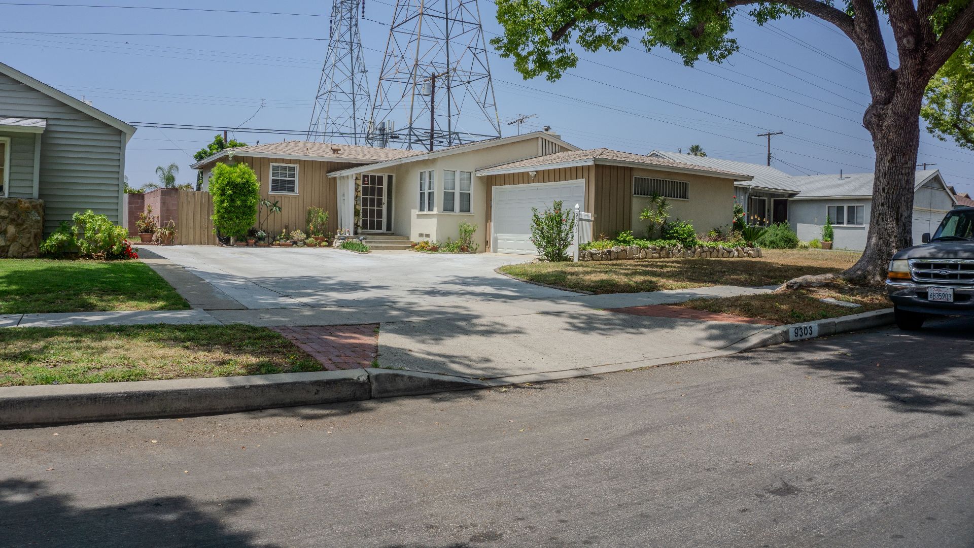 Charming suburban street with mid-century homes and lush greenery on a sunny day.