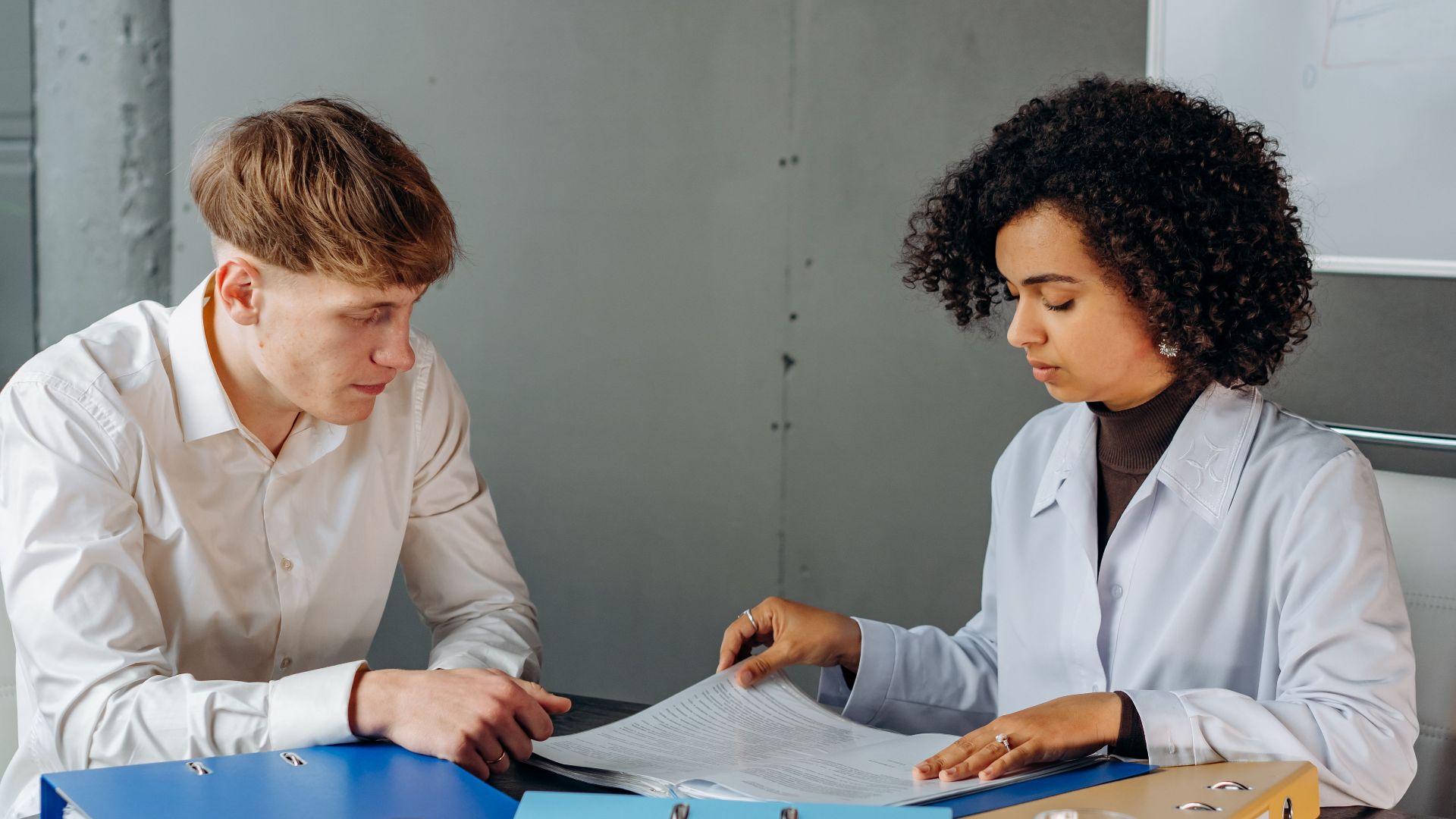 Two colleagues discussing important business documents at an office desk.