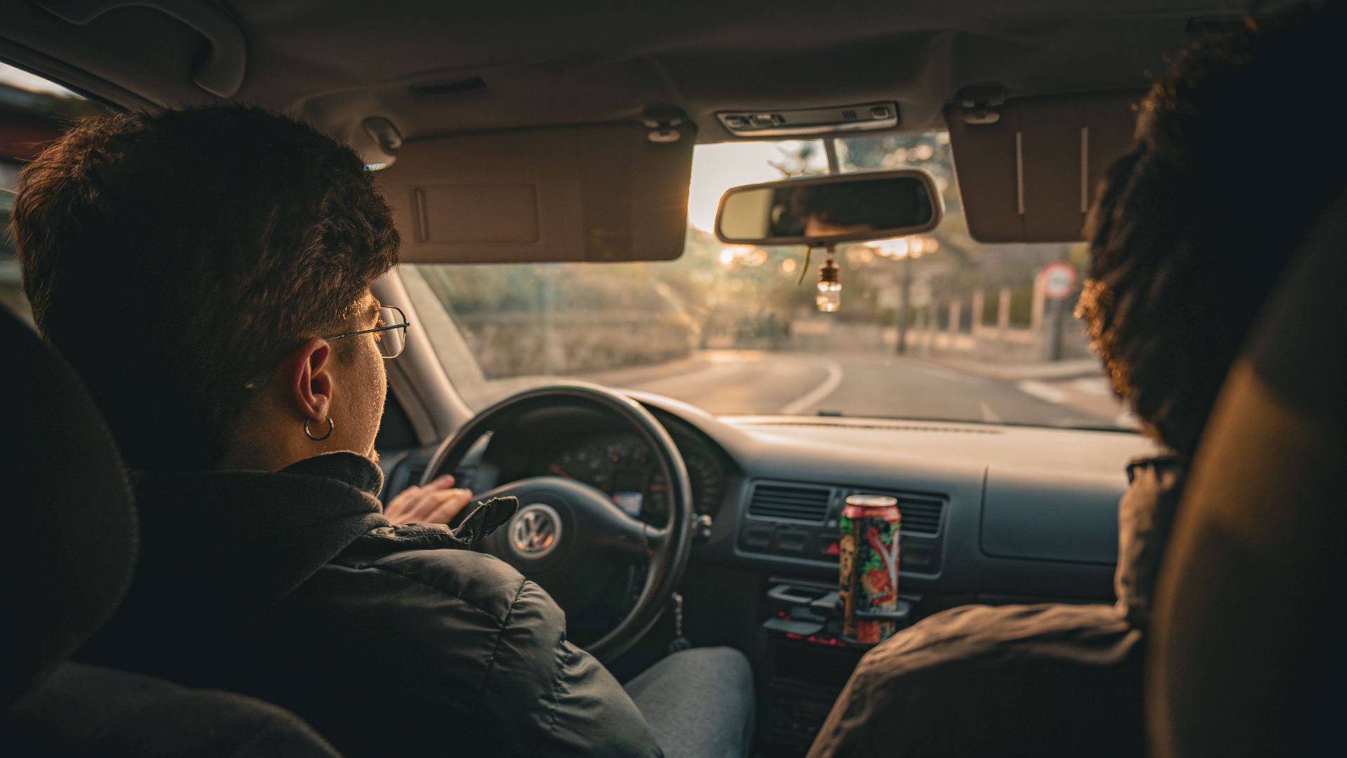 Two people driving in a car enjoying a sunset view in a city landscape. Modern lifestyle and travel vibe.