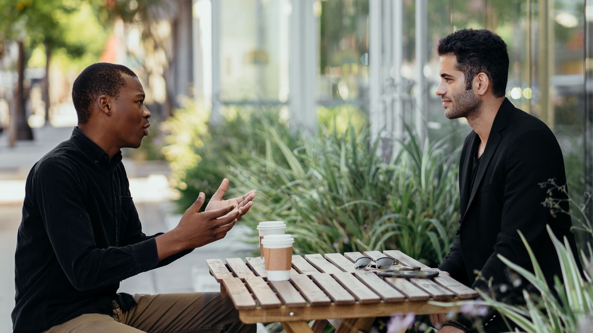 Two men having a business meeting at an outdoor café setting.