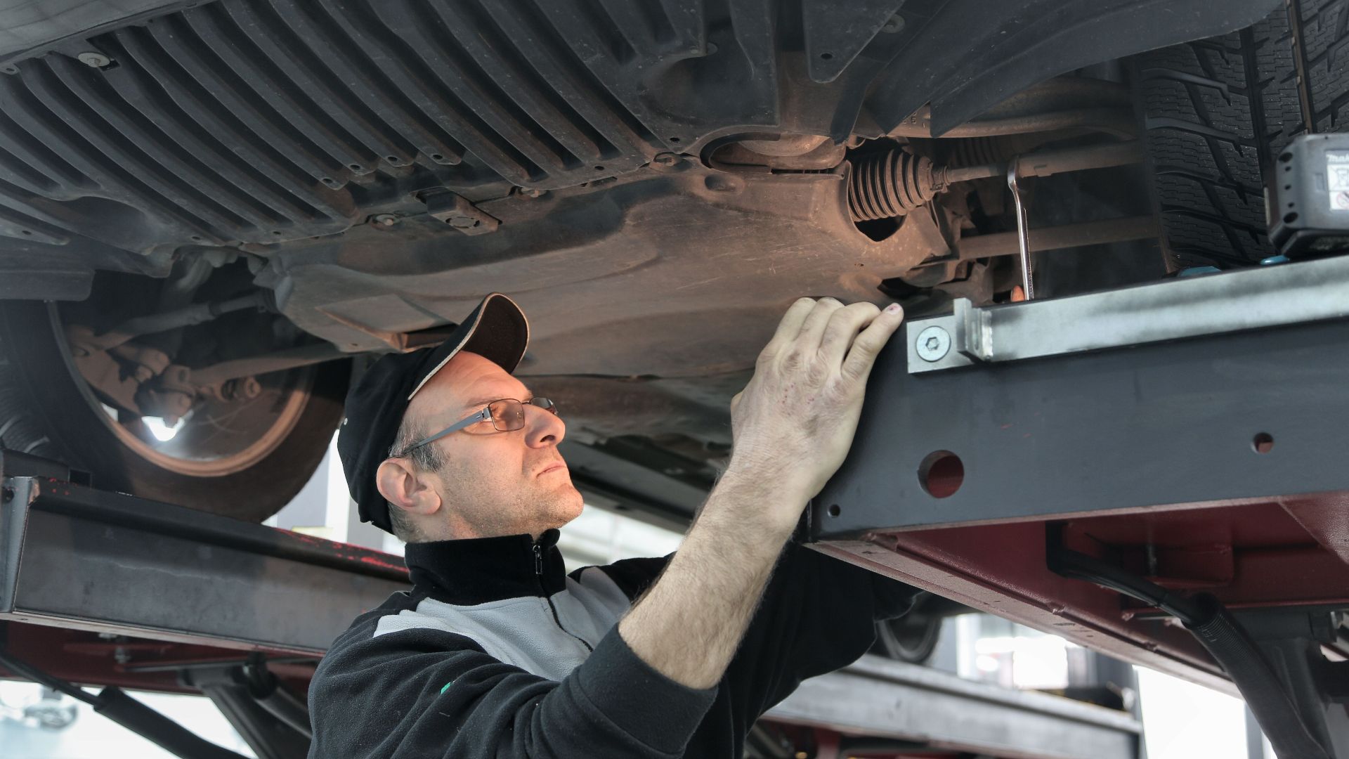 Professional mechanic conducting vehicle inspection in an auto workshop.