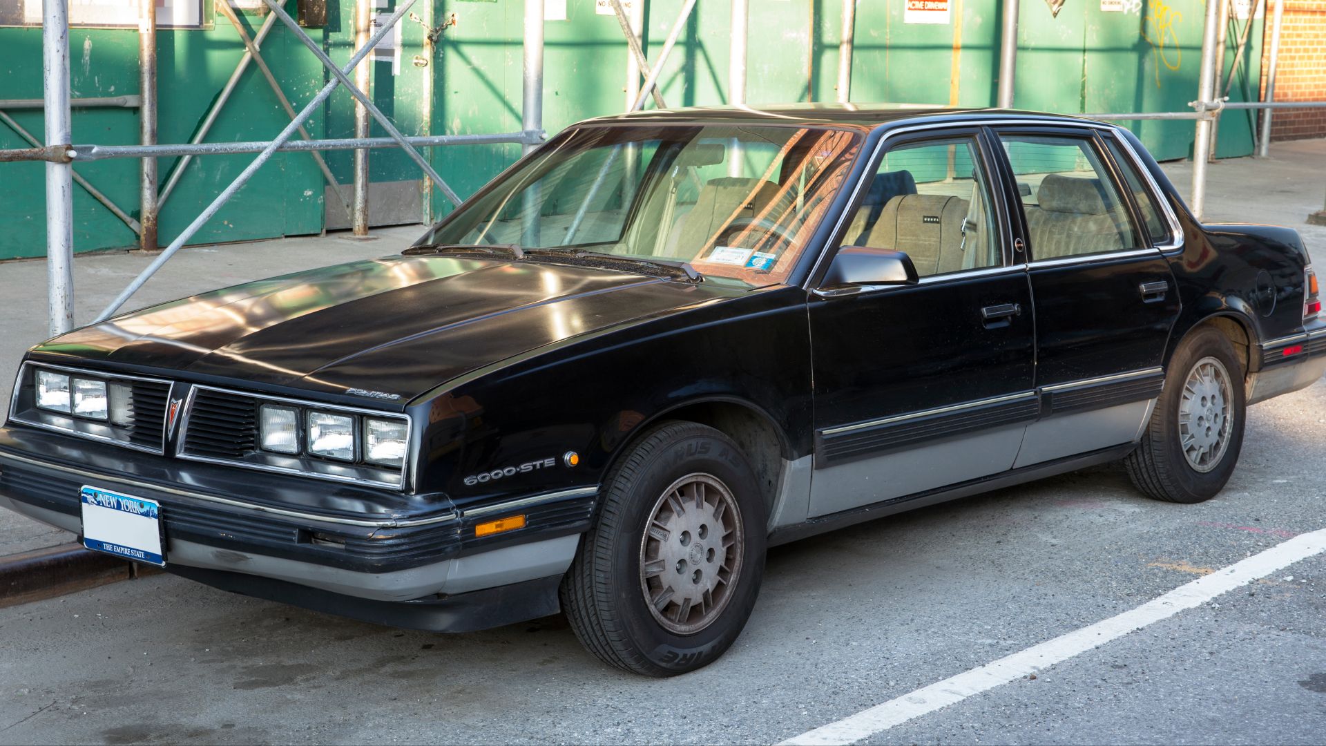 A 1985 Pontiac 6000 STE in black over silver in Astoria, NY.
